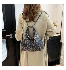Detail view of large leopard print bucket bag featuring soft leather texture and dual straps
