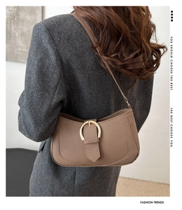Detail view of coffee-colored pebble leather shoulder bag with vintage gold clasp