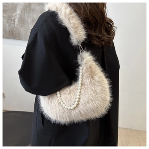 Close-up of plush faux fur hobo bag featuring large pearl handle and soft apricot texture