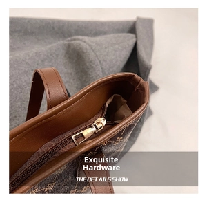 Macro detail of high-quality golden hardware and printed leather on a brown tote bag