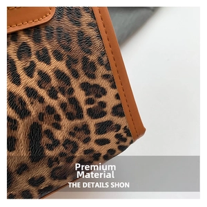 Macro detail of leopard print fabric texture and premium brown leather stitching trim