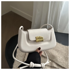 Detailansicht der weißen Leder-Baguette-Tasche mit goldfarbenem Schokoladen-Verschluss