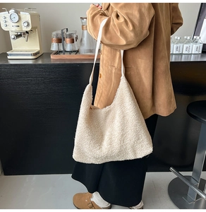 Beige plush tote bag shown on shoulder with soft fleece texture and spacious design