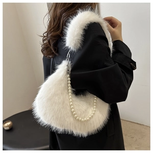 Detail of white plush shoulder bag featuring a decorative pearl chain and soft faux fur