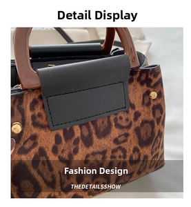 Detail view of leopard print tote bag with brown handles and golden rivet accents