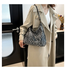 Side view of large leopard print hobo bag worn with a chic beige trench coat