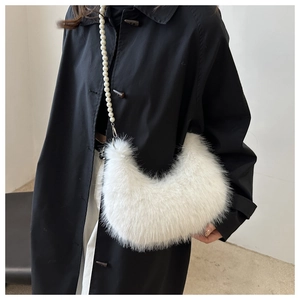 Close-up of white faux fur crescent bag featuring elegant pearl shoulder strap chain