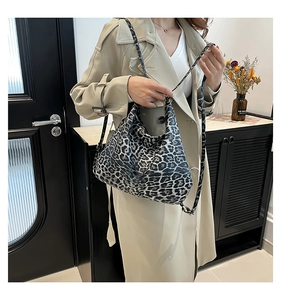 Detail of leopard print bucket bag with smooth texture and sleek metal zipper closure