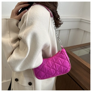Detail of rose pink quilted hobo bag with silver chain strap shown on person