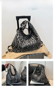 Detailed views of a black leopard print large tote bag on luggage and being held