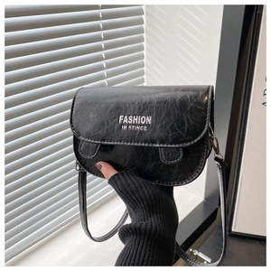 Detail of vintage black saddle bag with silver Fashion In Stince text and flap closure