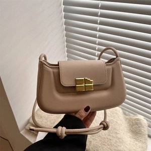 Minimalist beige baguette bag with golden chocolate buckle and knotted shoulder strap