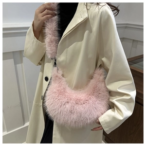 Detailed close-up of a pink faux fur crescent shoulder bag with soft plush texture