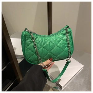 Close-up of green quilted nylon shoulder bag with silver chain and stitched rhombus pattern