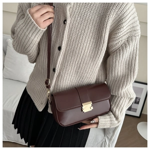 Detailed view of deep brown vintage crossbody bag with gold metal buckle and leather strap