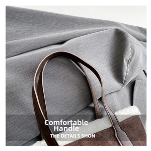 Detail of dark brown faux suede bucket bag with white faux shearling trim and handles