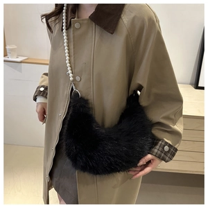 Detail of black faux fur crescent bag featuring a stylish large pearl chain strap