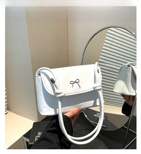 Détail du sac blanc avec nœud argenté et bandoulière en corde épaisse nouée à la main