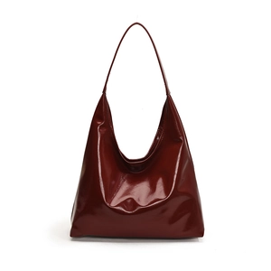 Minimalist deep red patent leather hobo tote bag with a high-gloss finish and slim shoulder strap