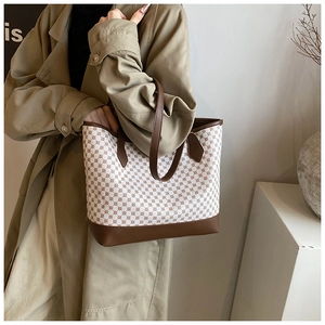 Detail of vintage tote bag featuring retro floral pattern and brown leather straps