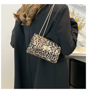 Dettaglio borsa leopardata con catena dorata indossata sopra un blazer nero chic