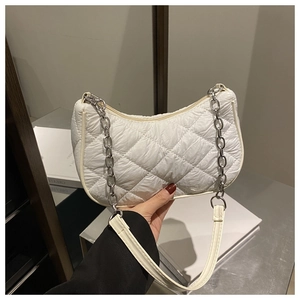 Detailed view of white quilted shoulder bag with silver chain and chic leather strap