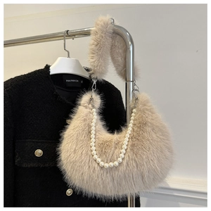 Detail of beige faux fur shoulder bag with elegant pearl chain and soft fluffy texture