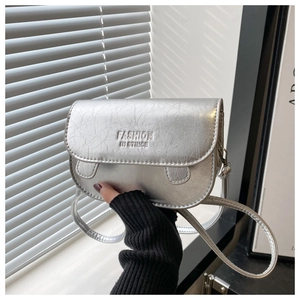 Detail of silver saddle bag with metallic wrinkled texture and fashion lettering
