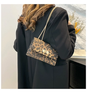 Dettaglio borsa leopardata con tracolla a catena dorata e chiusura a girello in metallo