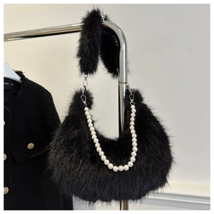 Detail of black faux fur crescent bag featuring a fluffy handle and pearl chain strap