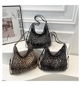 Three leopard print hobo bags in different colors displayed on a white tiered stand