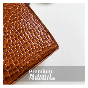 Detailed close-up of brown embossed crocodile texture leather with glossy finish