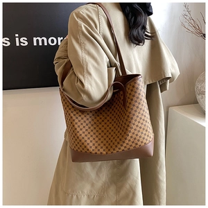 Detailed view of vintage large tote bag with geometric pattern worn with a khaki trench coat