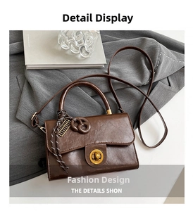Detail of vintage coffee leather crossbody bag featuring gold clasp and silk scarf charm
