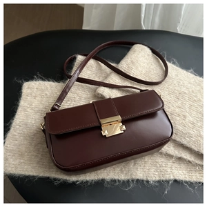 Detail of vintage dark brown leather bag with a polished gold square buckle