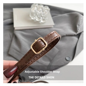 Close-up of adjustable dark brown leather shoulder strap with golden metal buckle