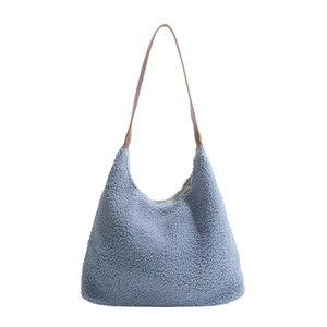 Winter plush tote bag in blue fleece with brown leather straps on white background