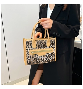 Macro detail of leopard print tote bag featuring camel leather trim and metal zipper