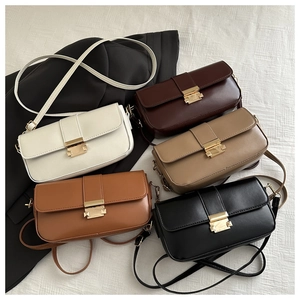 Flat lay of multiple minimalist leather crossbody bags in five colors with gold buckles