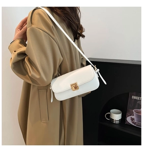 Gros plan d'un sac bandoulière en cuir blanc avec fermoir rotatif doré sur un mannequin