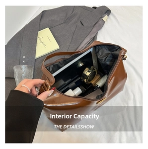 Internal capacity view of brown faux leather tote bag holding a tablet and cosmetics
