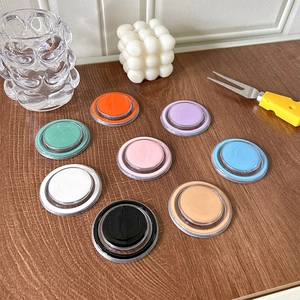 Detail showing colorful magnetic pop socket stands on a minimalist wooden desktop setup