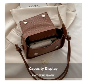 Detail of brown leather handbag interior with woven pattern and magnetic silver closure