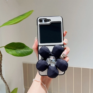 Detail of white leather foldable case with large 3D black fabric flower and crystal core