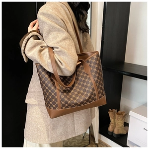 Detailed side view of vintage geometric tote bag with brown leather trim and handle