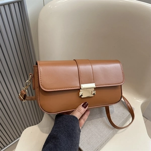 Brown rectangular crossbody bag with vintage gold clasp on books for a stylish look