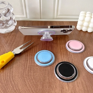 Close-up of circular magnetic phone grips in purple, pink, blue, black, and white colors