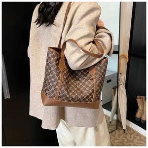 Detailed close-up of retro printed tote bag with brown leather trim and star patterns
