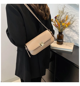 Detailansicht einer beigen minimalistischen Leder-Umhängetasche mit goldener Metallschnalle