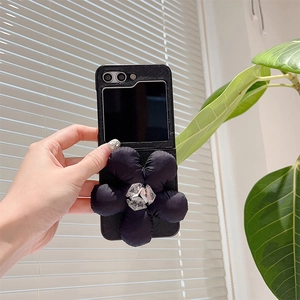 Detail of black leather folding phone case with 3D fabric flower and rhinestone